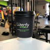 Individuell bedruckter Pappbecher mit schwarzem Deckel und 'Liberty Gym' Logo